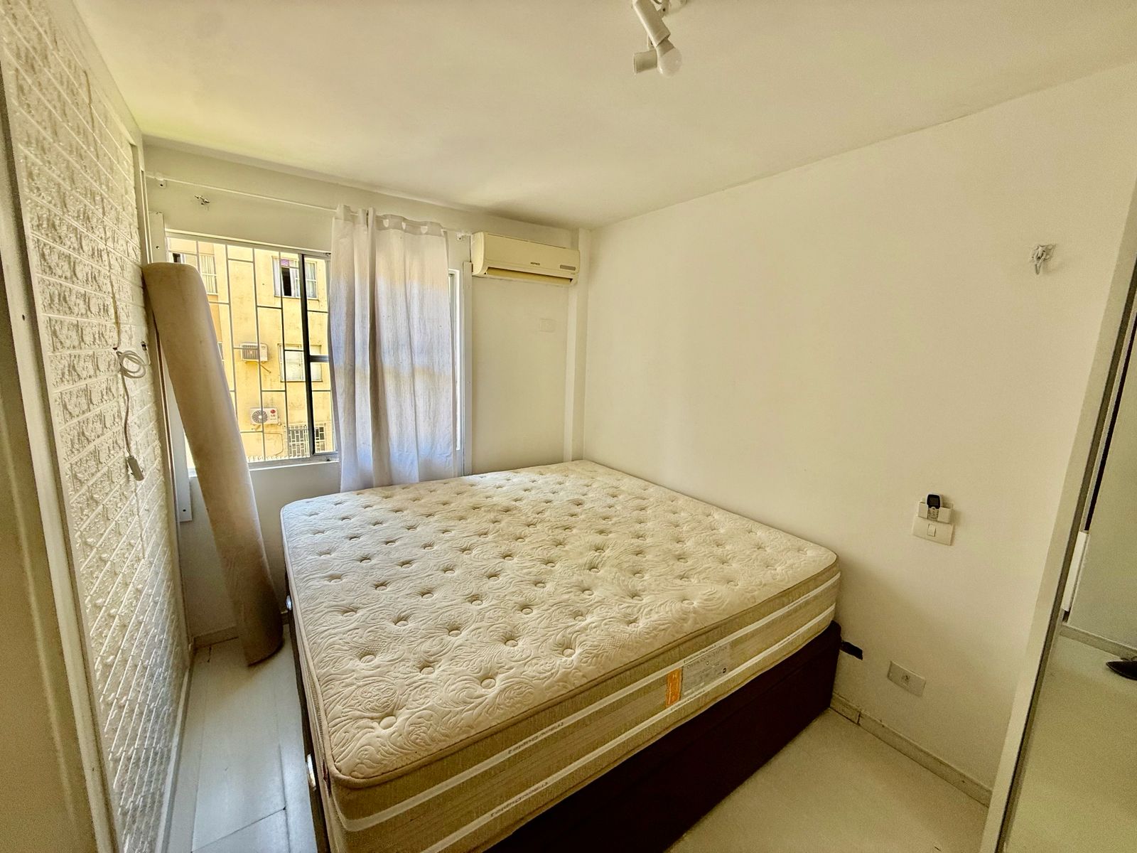 Dormitório principal com cama e ar condicionado